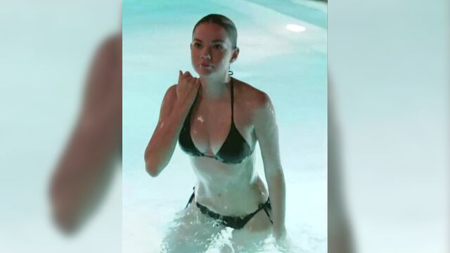 Maia Mitchell emerging from a pool in a black bikini